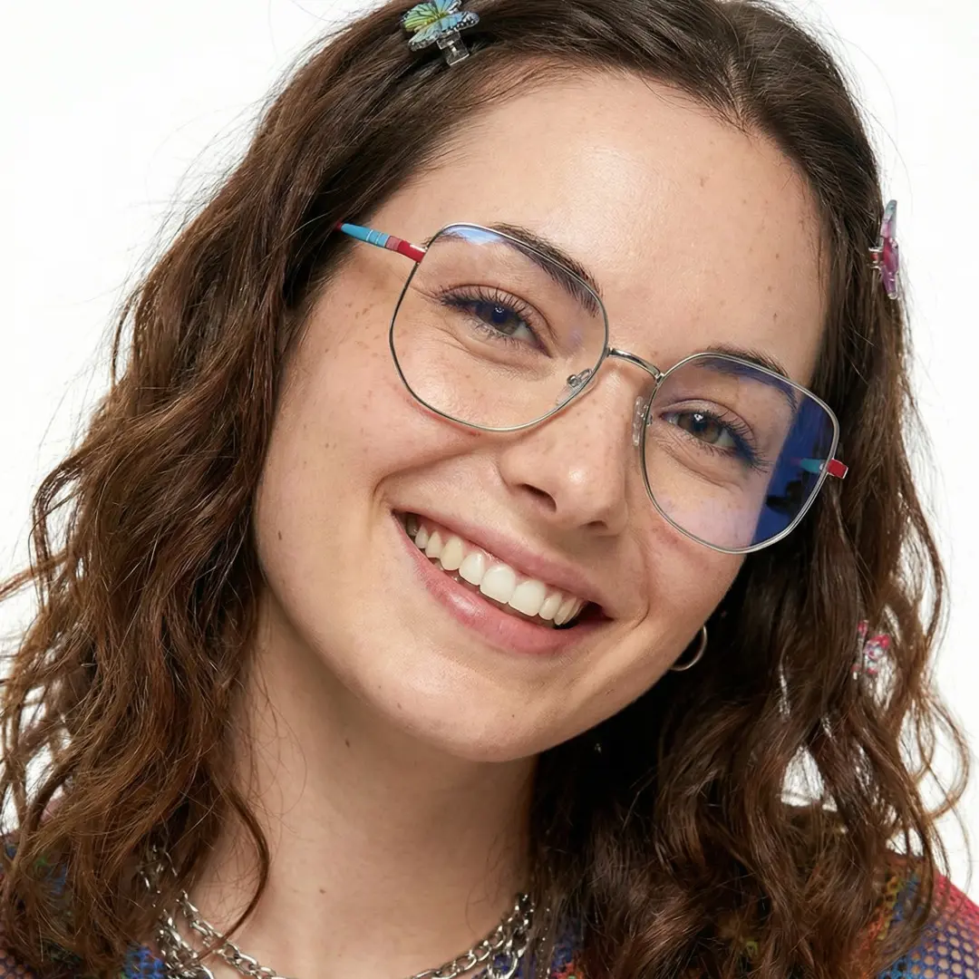 Front view of female wearing silver geometric eyeglasses, tilting head, smiling, GM0502302