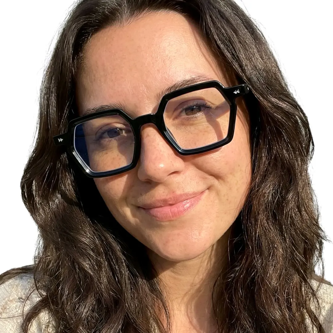 Front view of female wearing black geometric eyeglasses, tilting head, friendly smile, GP0132308