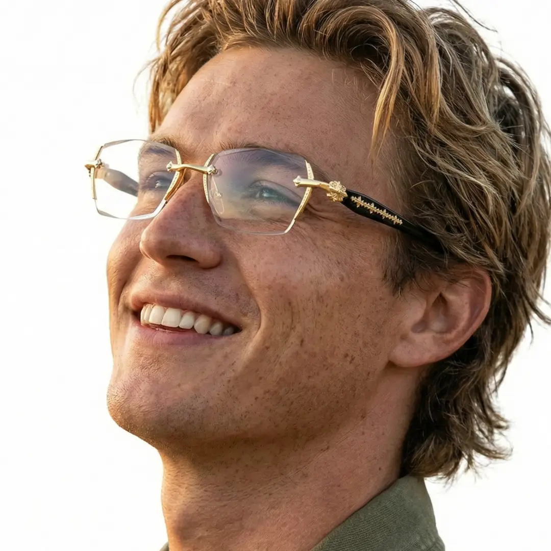 Three-quarter view of male wearing gold geometric eyeglasses, soft smile, GP0322512