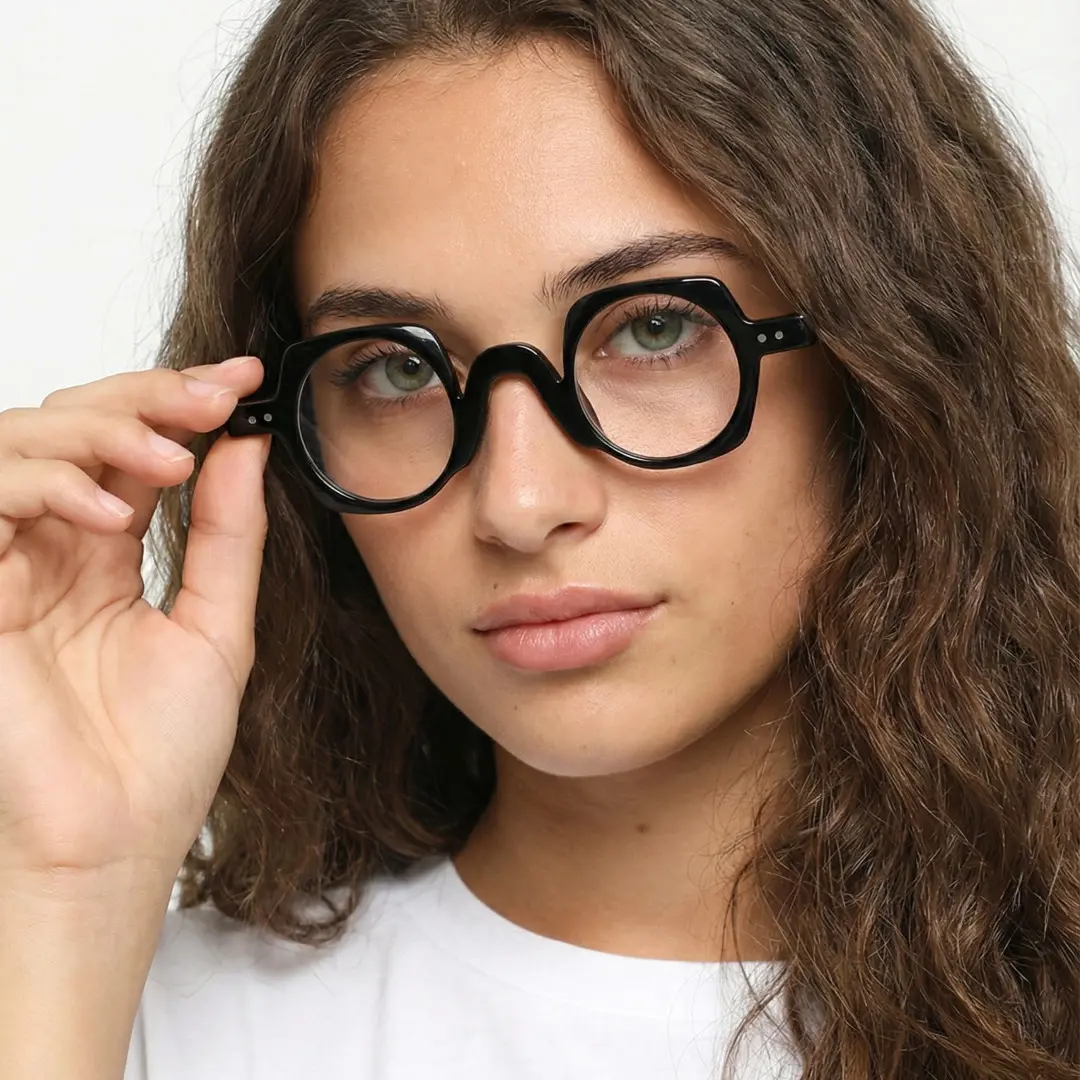 Face close-up view of female wearing black geometric eyeglasses, holding glasses, neutral expression, GP0342411