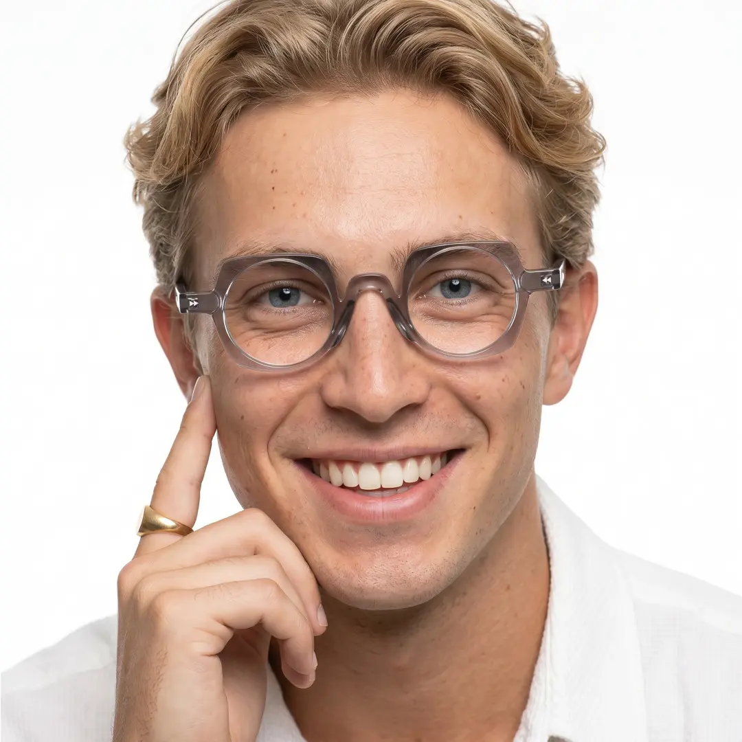 Front view of male wearing vintage grey geometric eyeglasses, hand near face, smiling, GP0342411