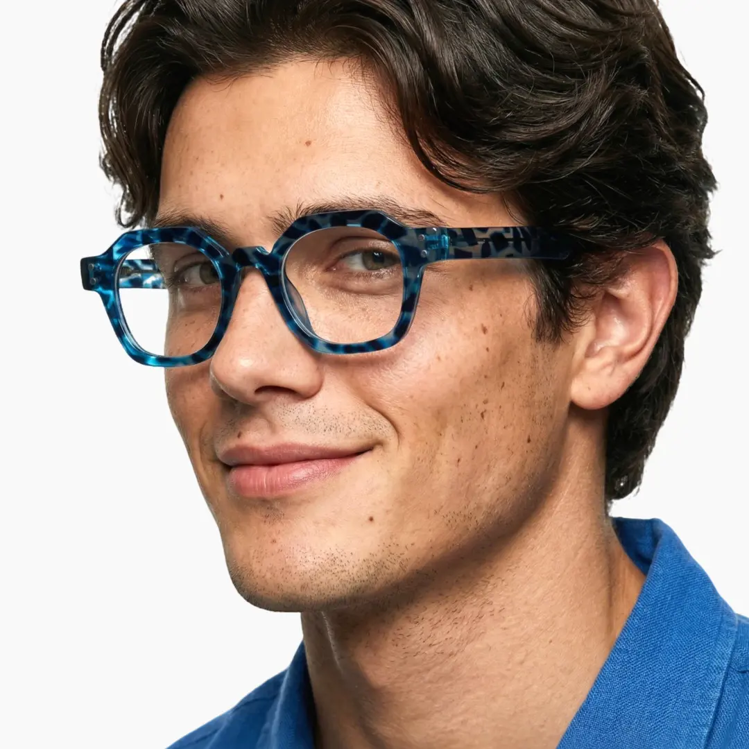 Profile view of male wearing vintage blue geometric eyeglasses, natural smile, GR0092308