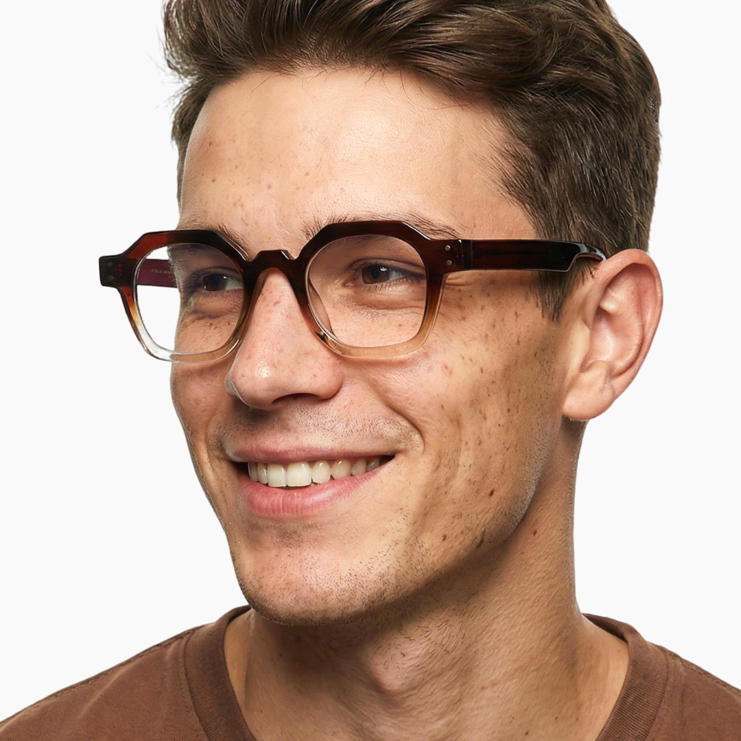 Looking away view of male wearing brown geometric eyeglasses, smiling, GR0092308