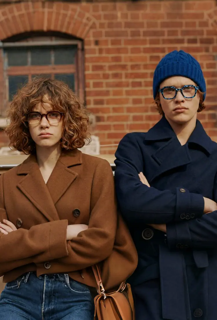 Two people model wearing vintage blue geometric tr90 eyeglasses in front of a red brick building. SPU: GR0092308