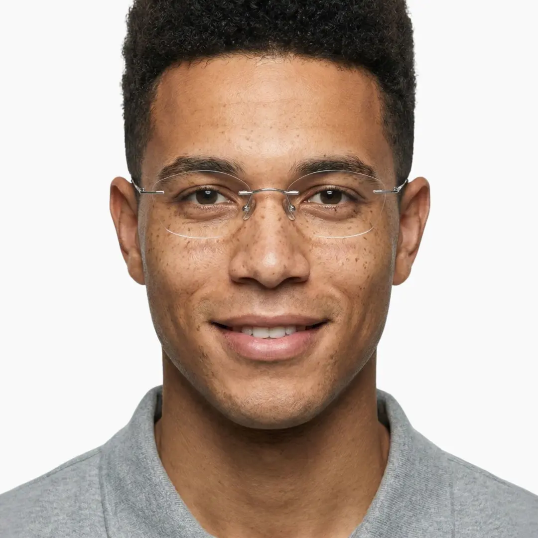 Front view of male wearing silver geometric eyeglasses, smiling, GT0092603