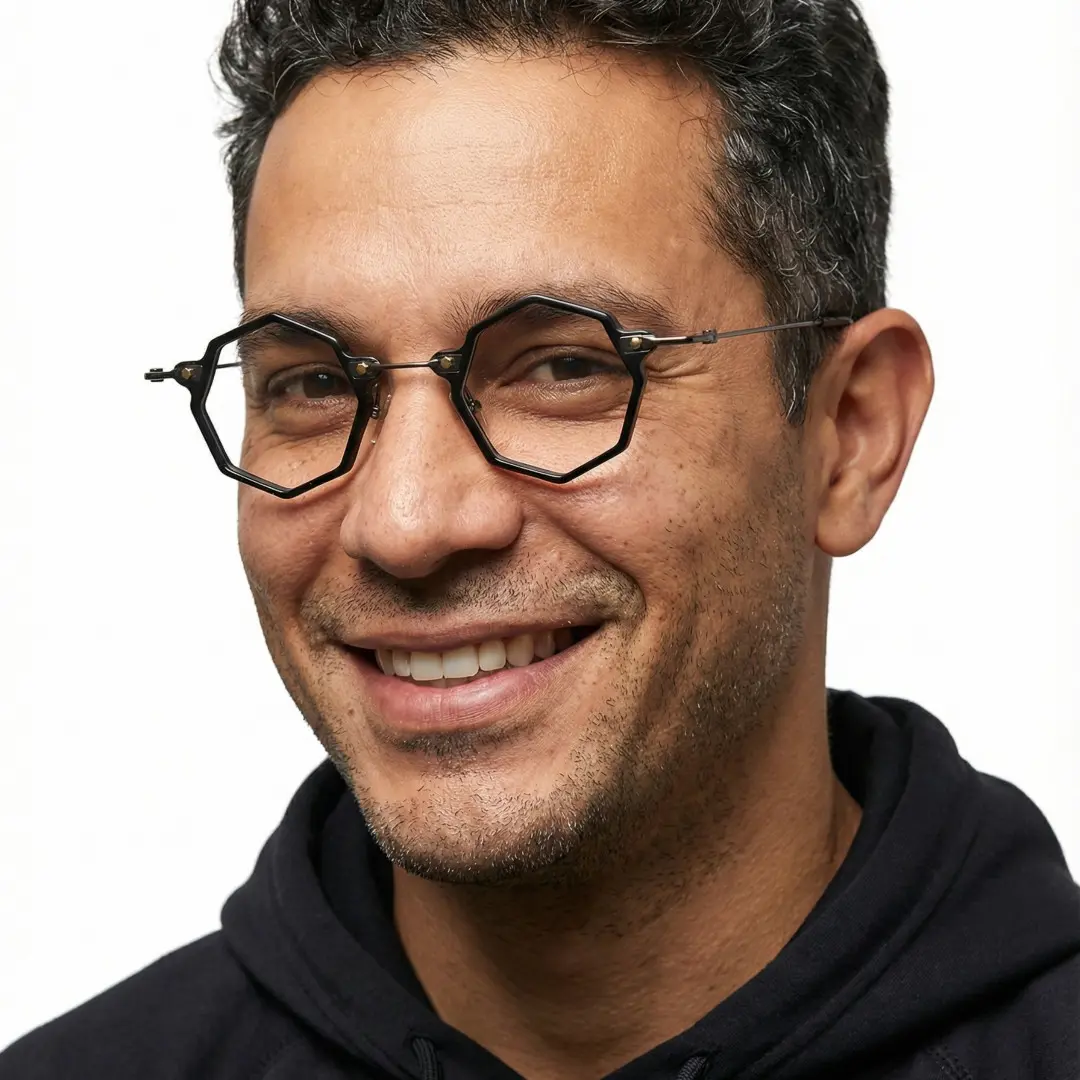 Three-quarter view of male wearing steampunk black geometric eyeglasses, wide smile, GT0332411