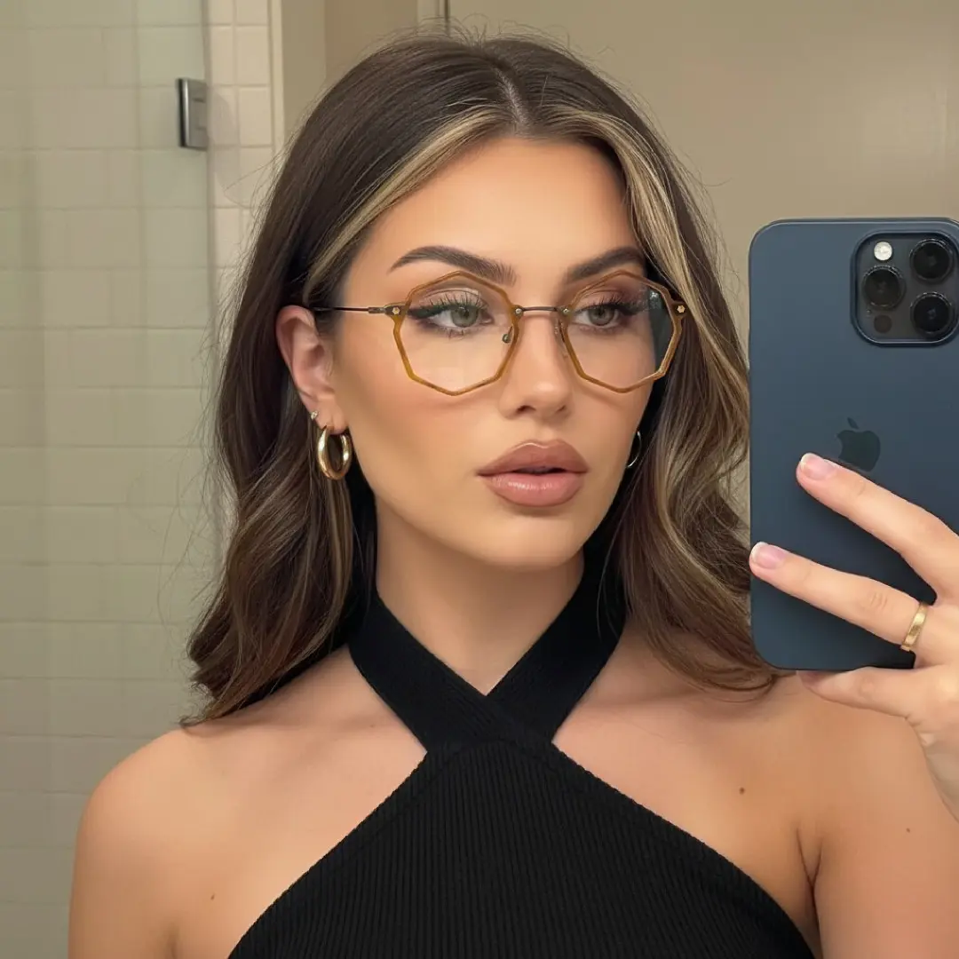 Three-quarter view of female wearing yellow geometric eyeglasses, Taking a selfie, neutral expression, GT0332411