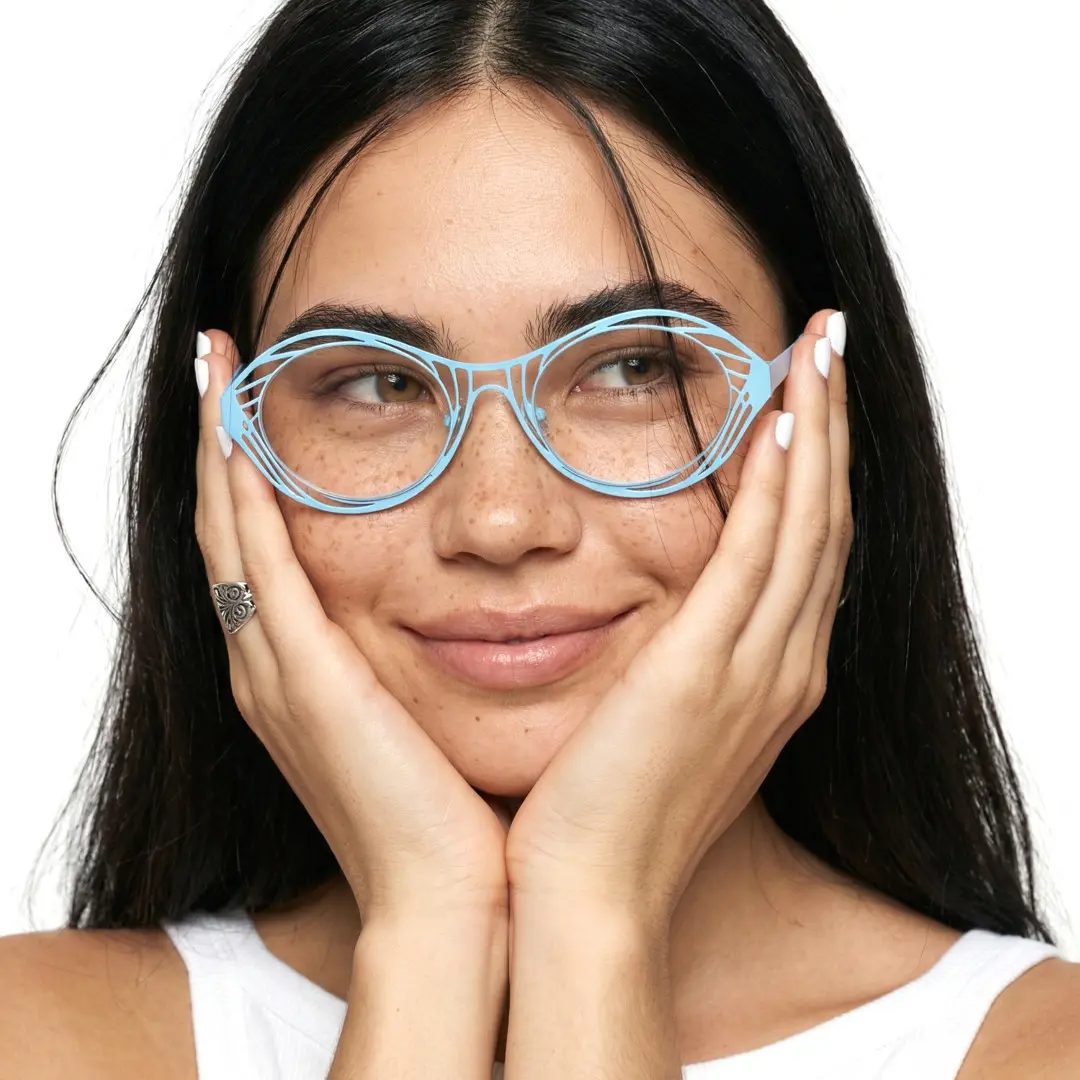 Looking away view of female wearing light blue oval eyeglasses, resting chin on hand, soft smile, OM0082212