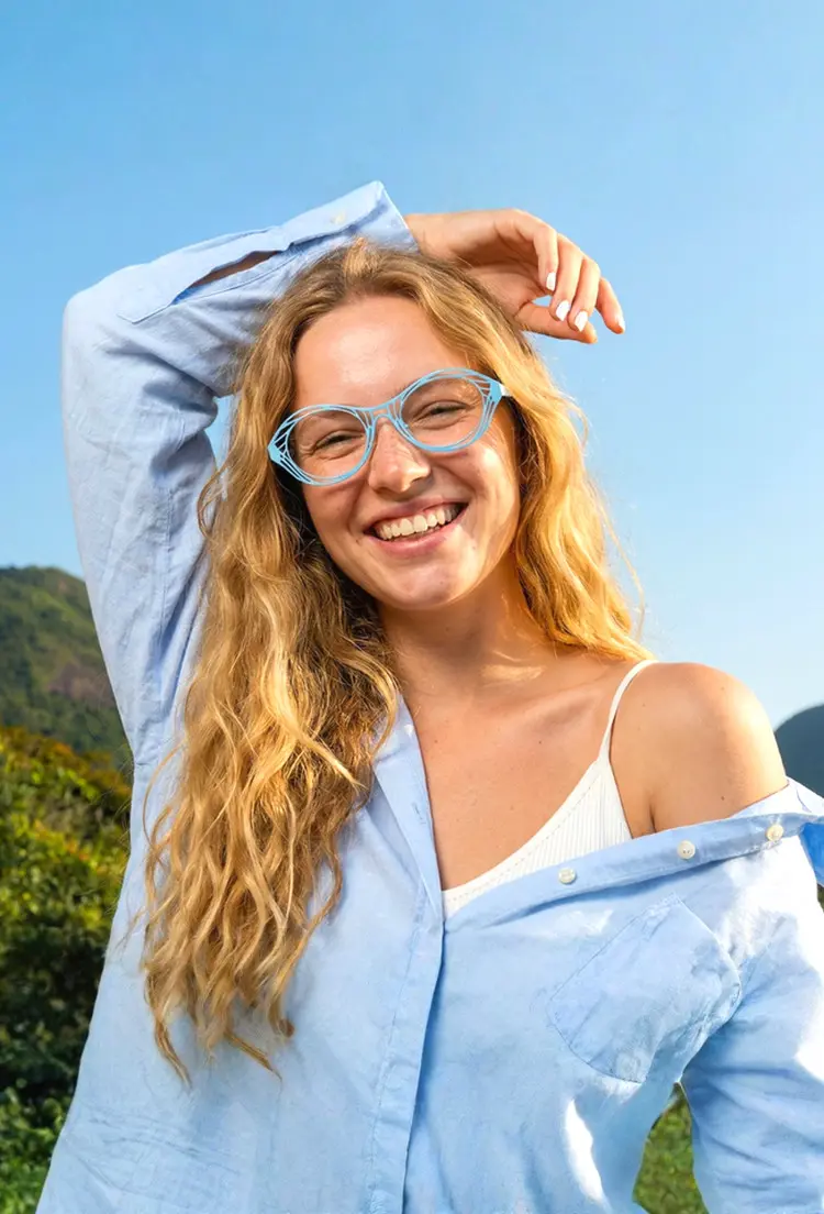Female model wearing elton john style blue oval metal eyeglasses in a studio setting. SPU: OM0082212