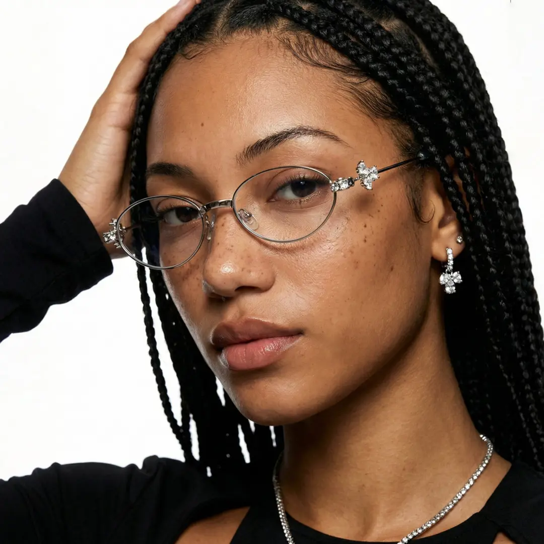 Front view of female wearing y2k silver oval eyeglasses, hand in hair, neutral expression, OM0252601