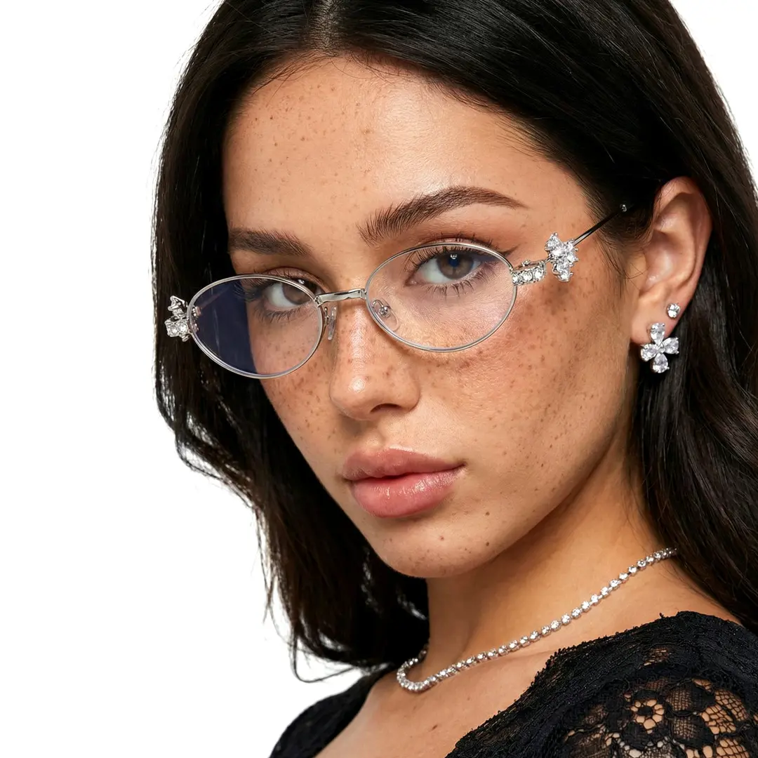 Three-quarter view of female wearing y2k silver oval eyeglasses, calm expression, OM0252601