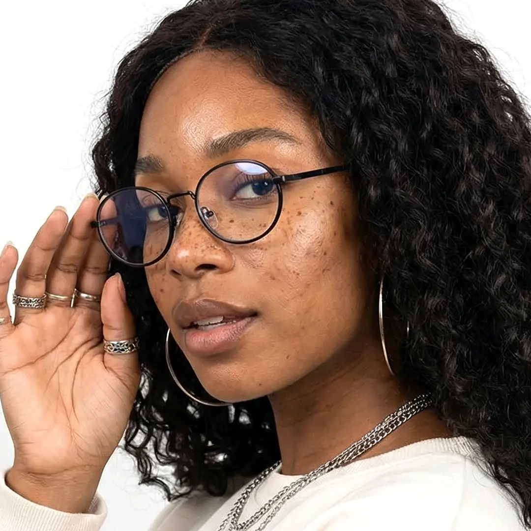 Three-quarter view of female wearing black oval eyeglasses, touching frame, neutral expression, OM0302410