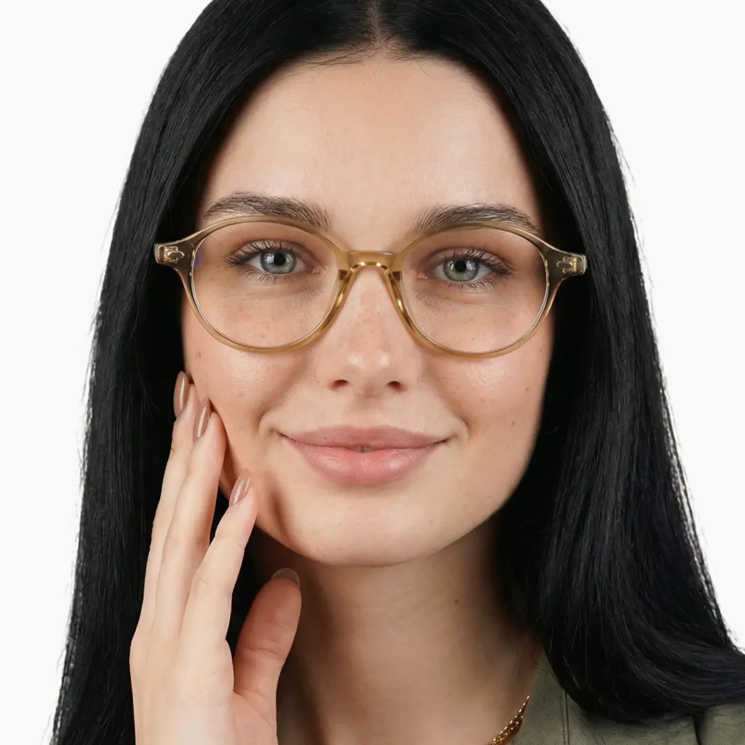 Front view of female wearing vintage bronze oval eyeglasses, hand near face, friendly smile, OR0082406