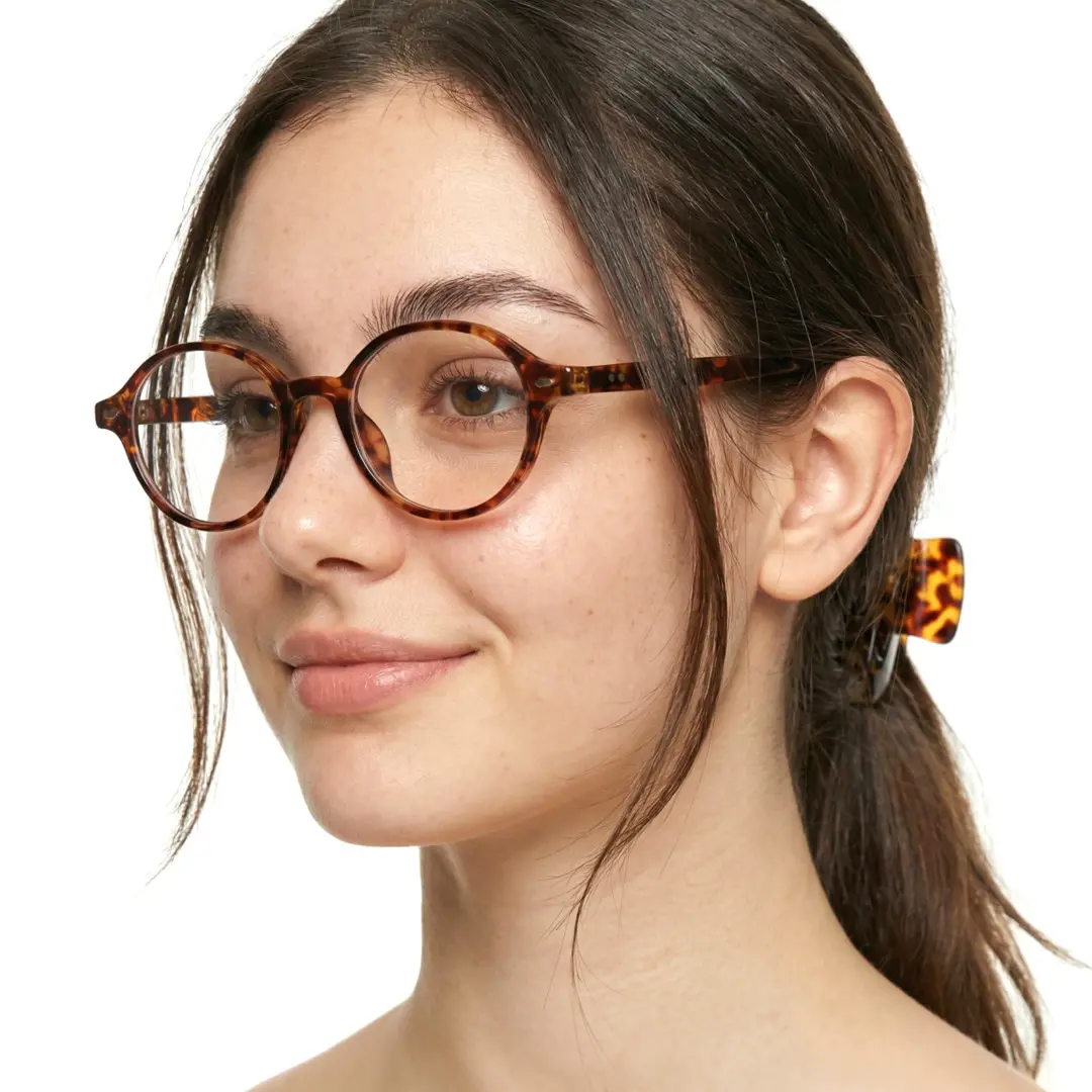 Three-quarter view of female wearing vintage tortoise oval eyeglasses, soft smile, OR0082406