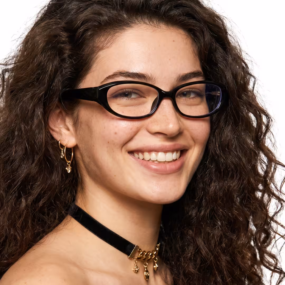 Female wearing office siren black oval tr90 eyeglasses, smiling. SPU: OR0232605