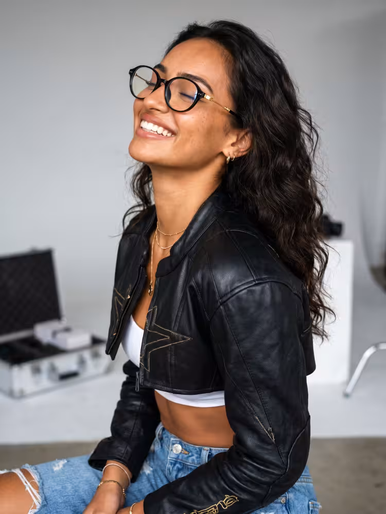 Female model wearing nerd black oval tr90 eyeglasses in a studio with blurred equipment background. SPU: OR0272410