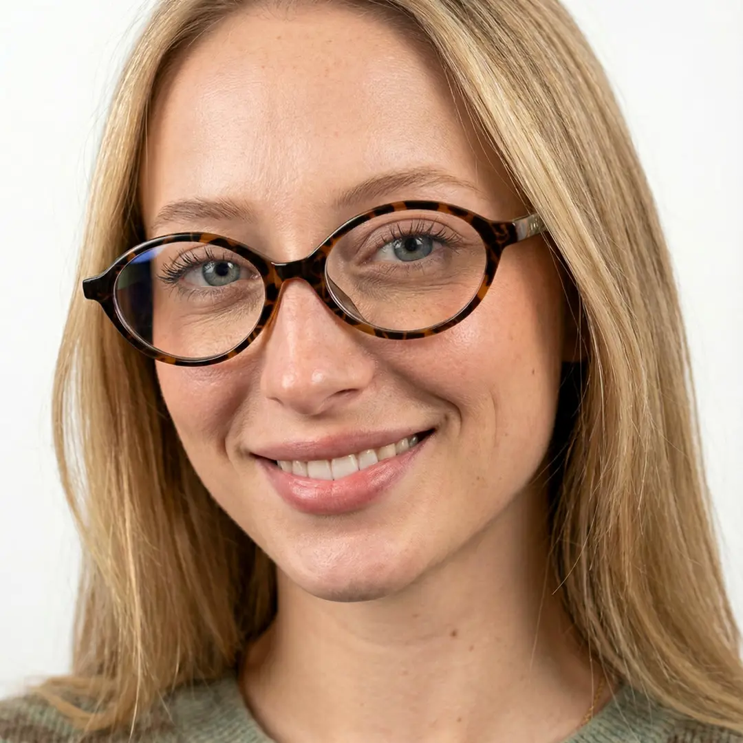Front view of female wearing brown tortoise oval eyeglasses, natural smile, OR0312402