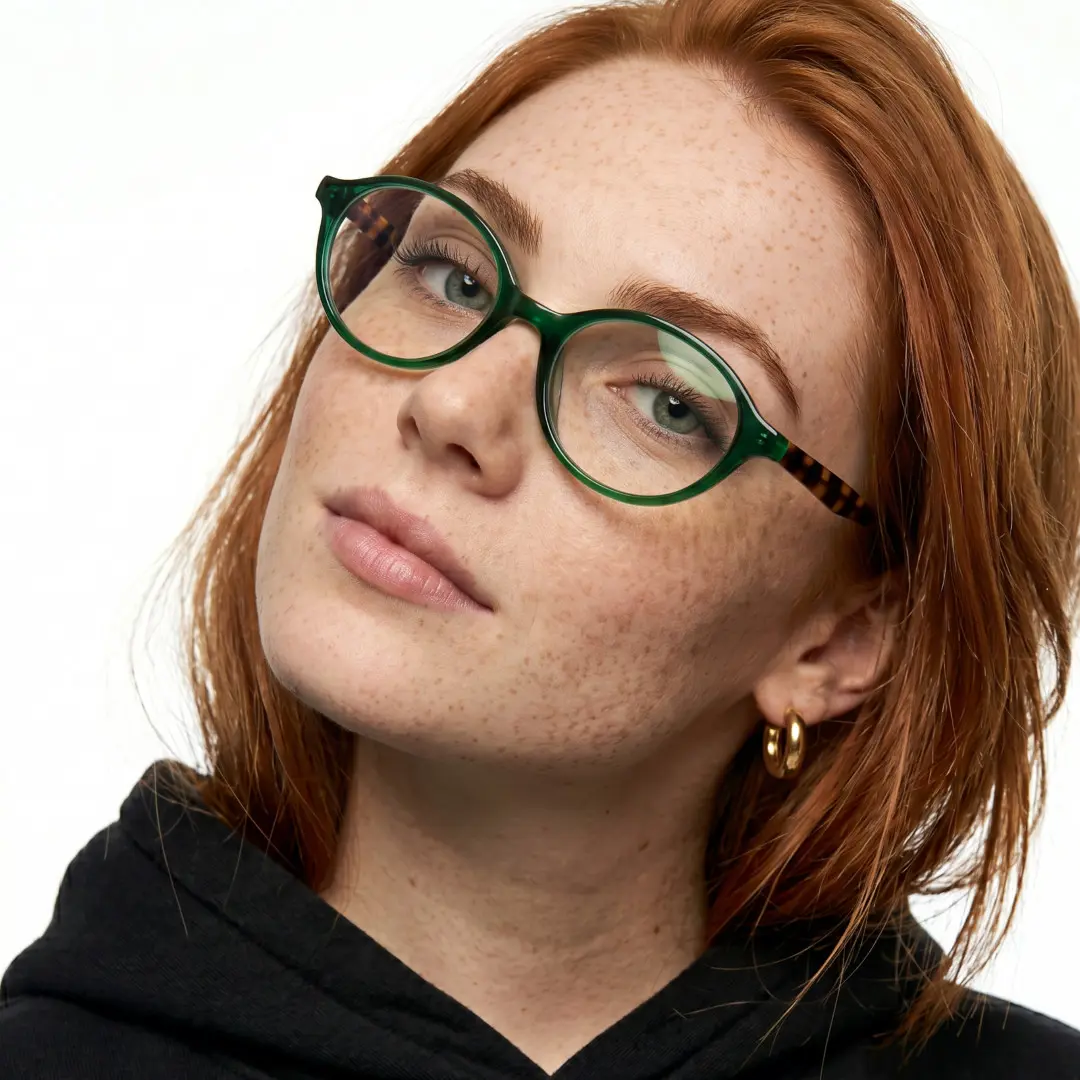 Front view of female wearing green oval eyeglasses, tilting head, natural smile, FS-OR0312402