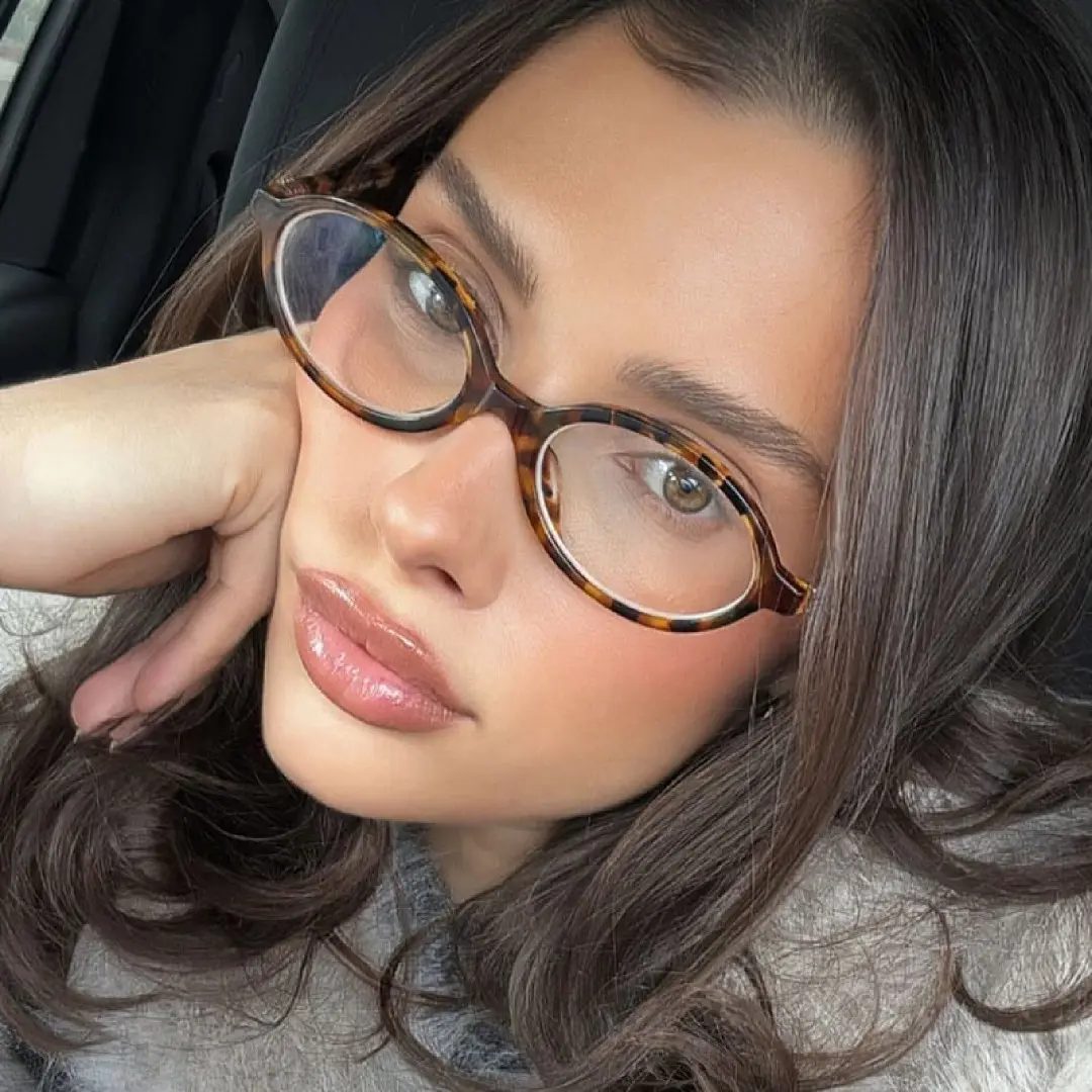 Front view of female wearing y2k tortoise oval eyeglasses, taking a selfie, neutral expression, OR0312402