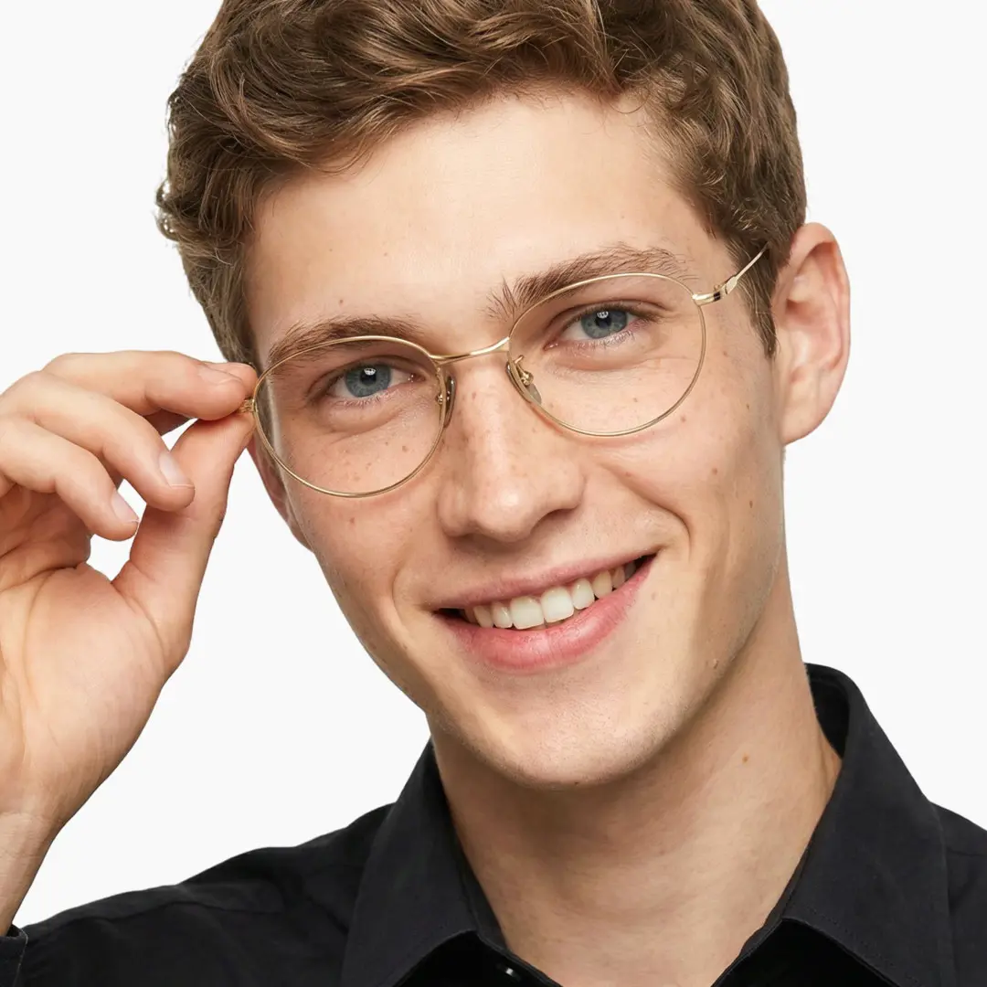 Front view of male wearing y2k gold oval eyeglasses, touching frame, natural smile, OT0072501