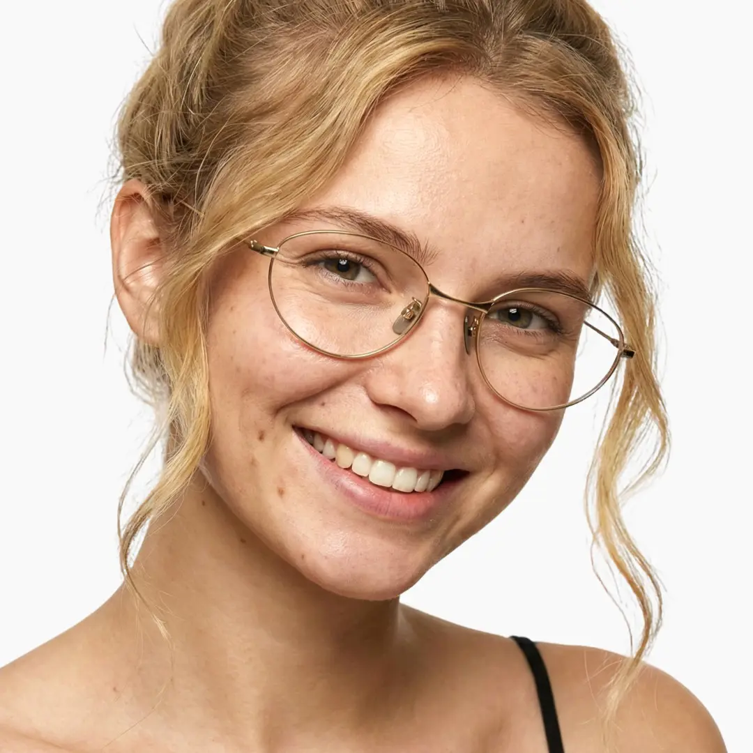 Front view of female wearing y2k gold oval eyeglasses, tilting head, natural smile, OT0072501