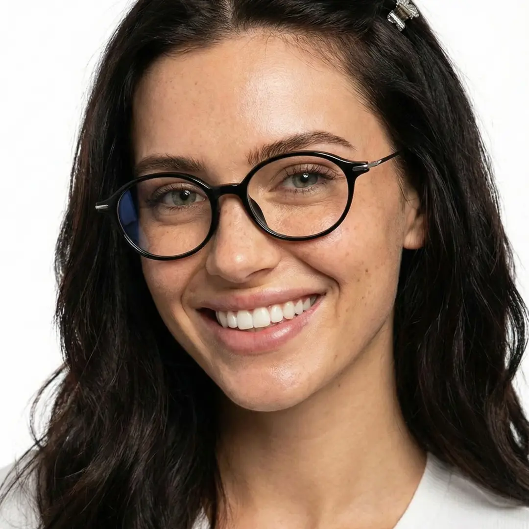 Three-quarter view of female wearing black oval eyeglasses, smiling, OT0102412