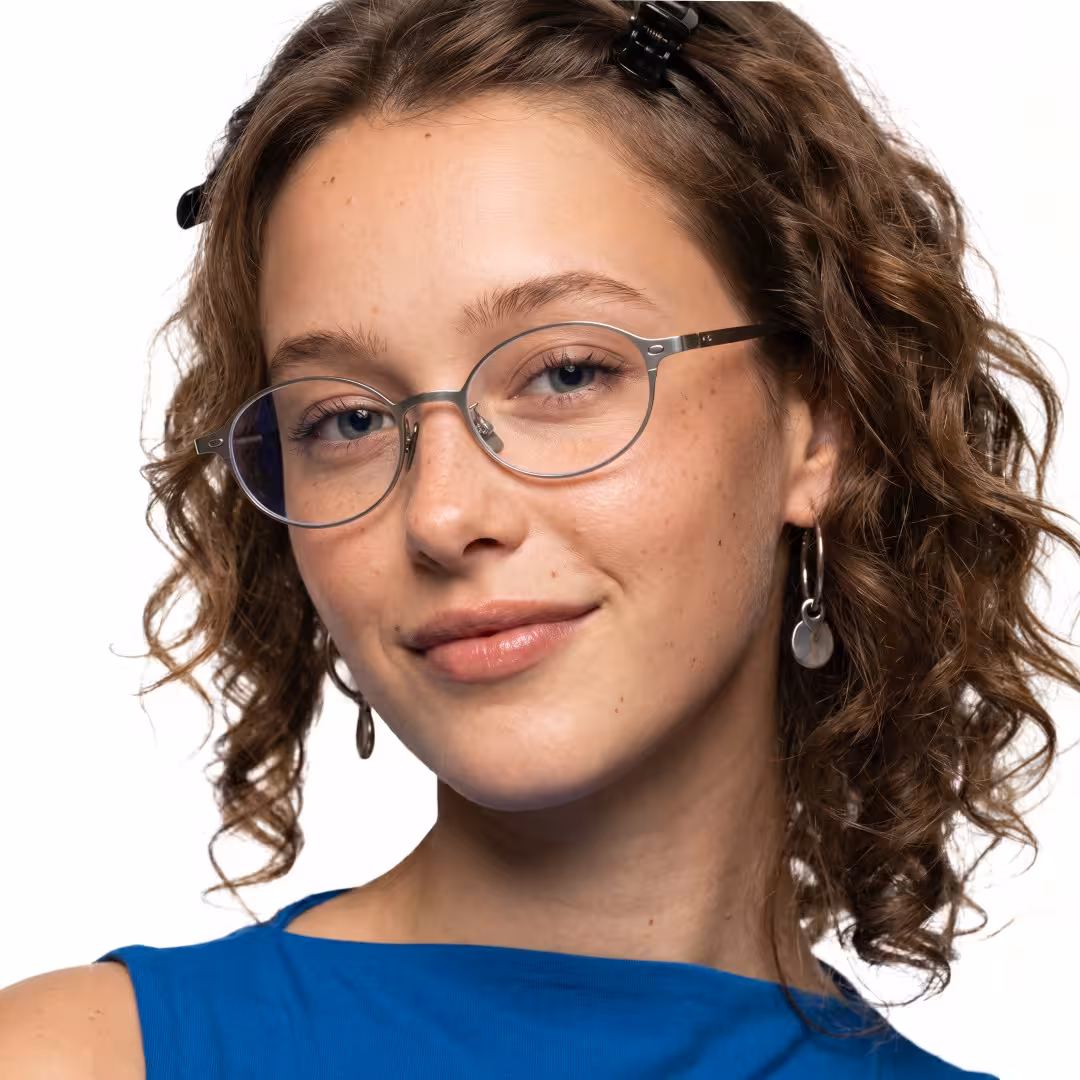 Front view of female wearing y2k silver oval eyeglasses, natural smile, OT0132412