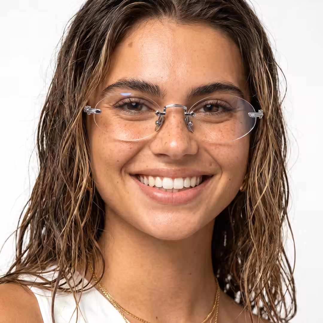 Front view of female wearing silver oval eyeglasses, natural smile, OT0142604