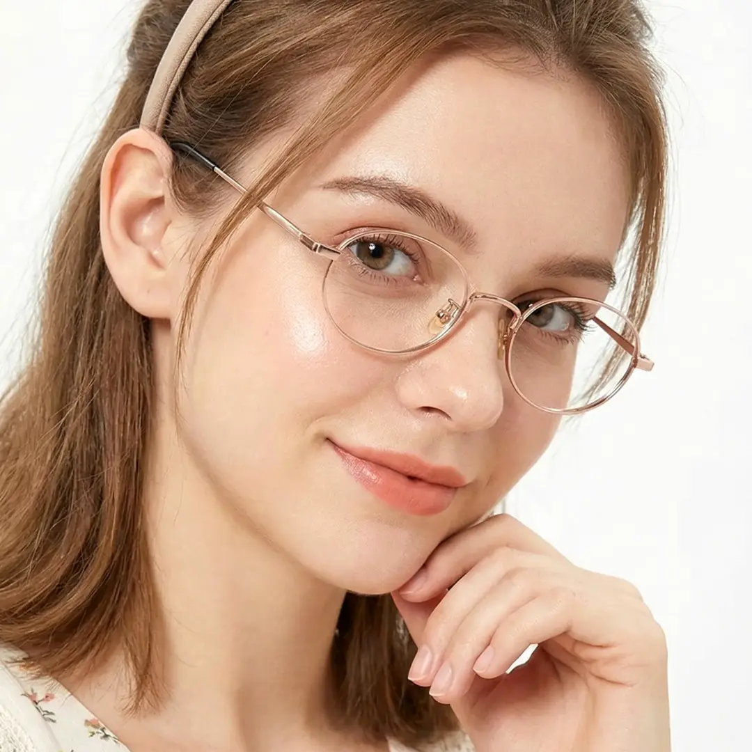 Profile view of female wearing gold oval eyeglasses, resting chin on hand, smiling, OT0282502