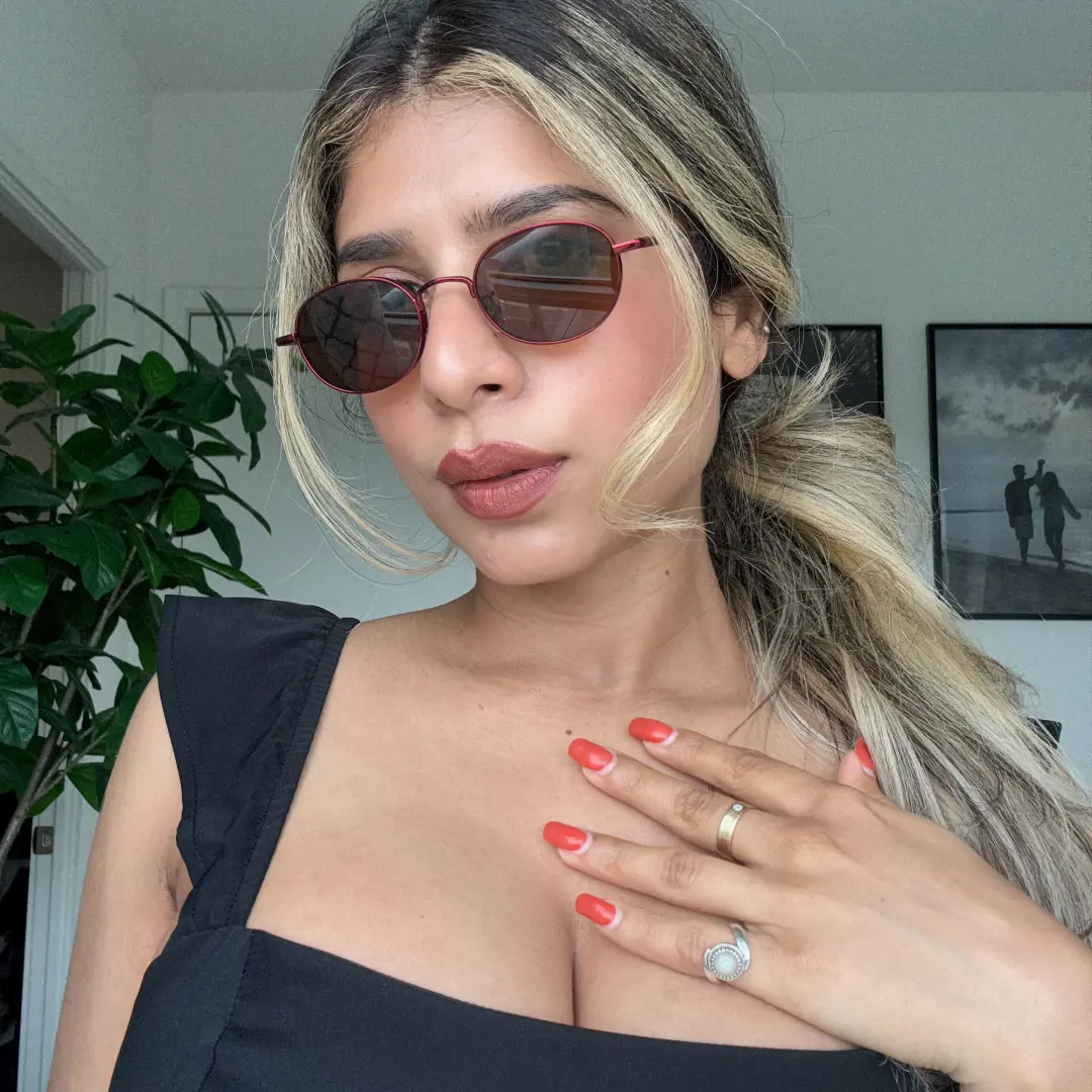 Three-quarter view of female wearing red oval eyeglasses, neutral expression, OT0282502