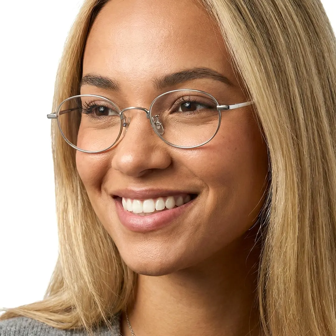 Three-quarter view of female wearing silver oval eyeglasses, smiling, OT0282502