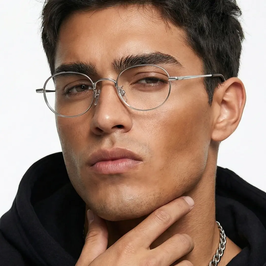 Three-quarter view of male wearing y2k silver oval eyeglasses, resting chin on hand, neutral expression, OT0282502