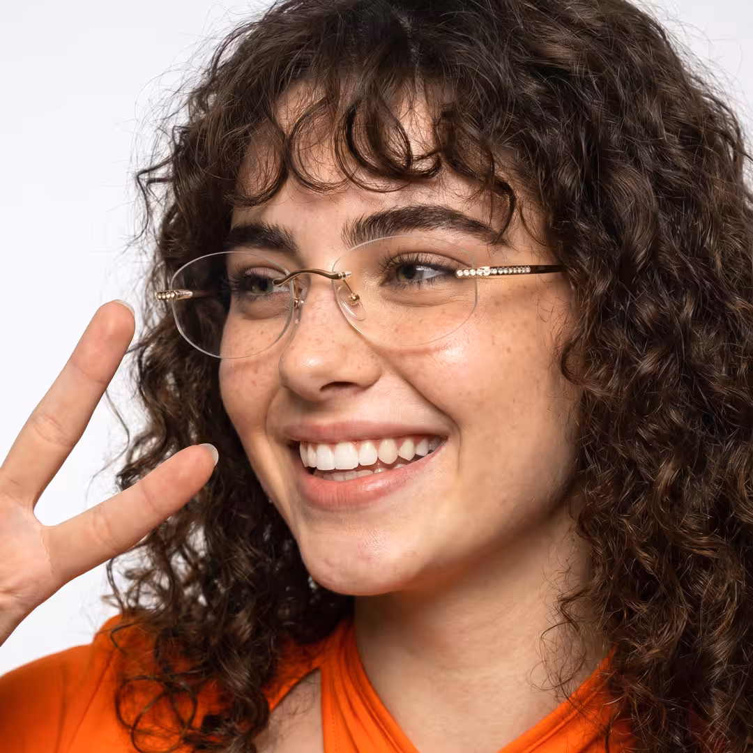 Female wearing fashion gold oval titanium eyeglasses, smiling. SPU: OT0312604
