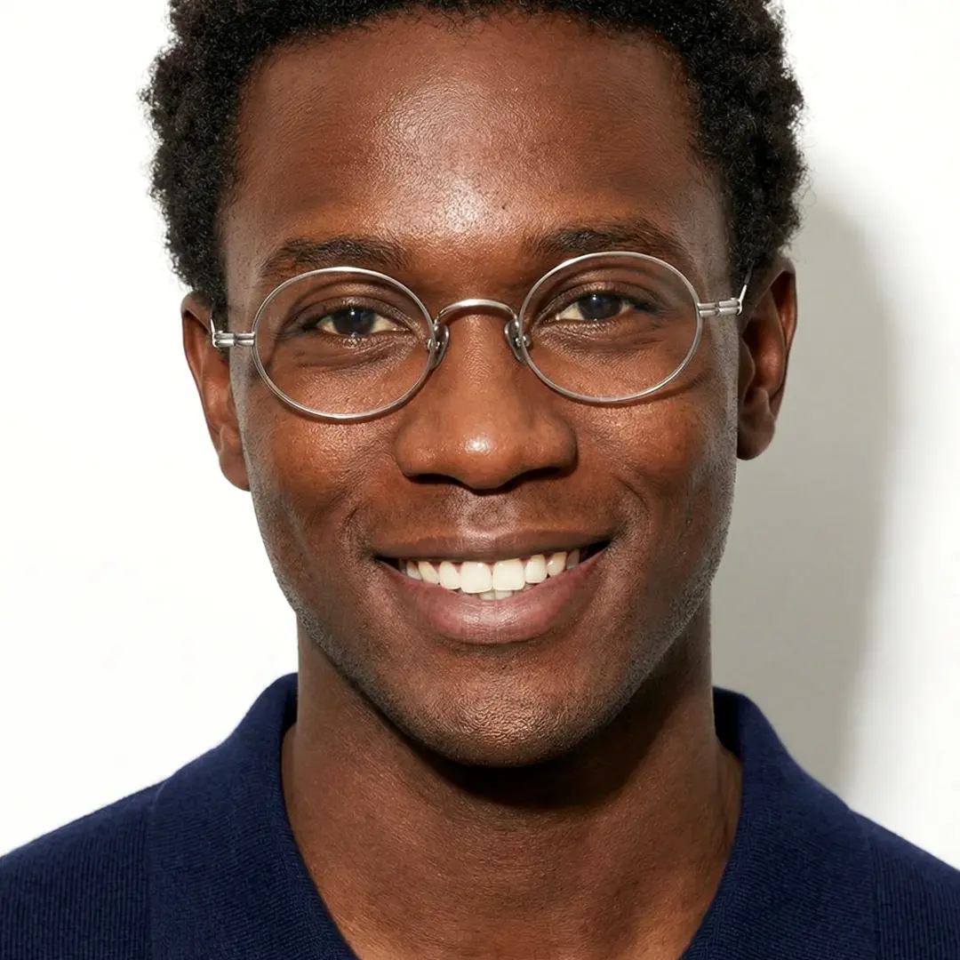 Looking straight ahead of male wearing silver oval eyeglasses, friendly smile, OT0402412