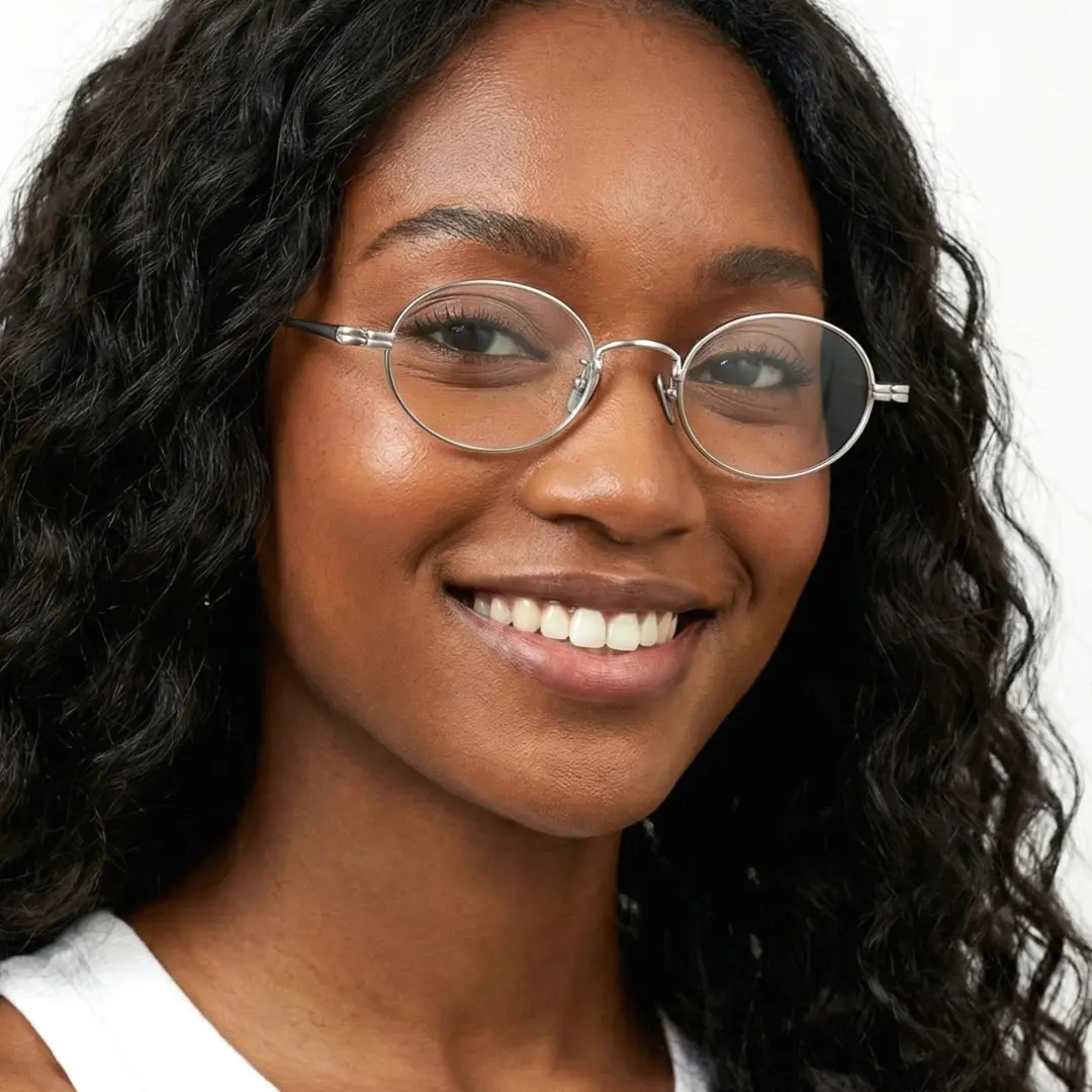 Three-quarter view of female wearing silver oval eyeglasses, natural smile, OT0402412