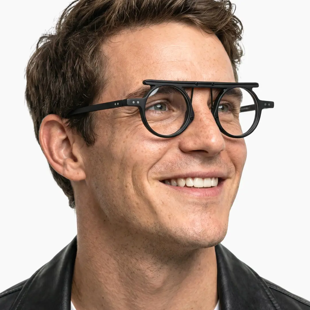 Profile view of male wearing vintage black round eyeglasses, smiling, RA0012405