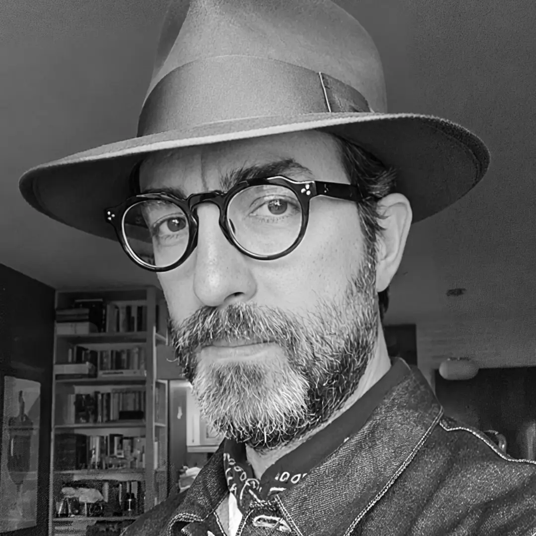 Over-the-shoulder view of male wearing green round eyeglasses, neutral expression, RA0012412