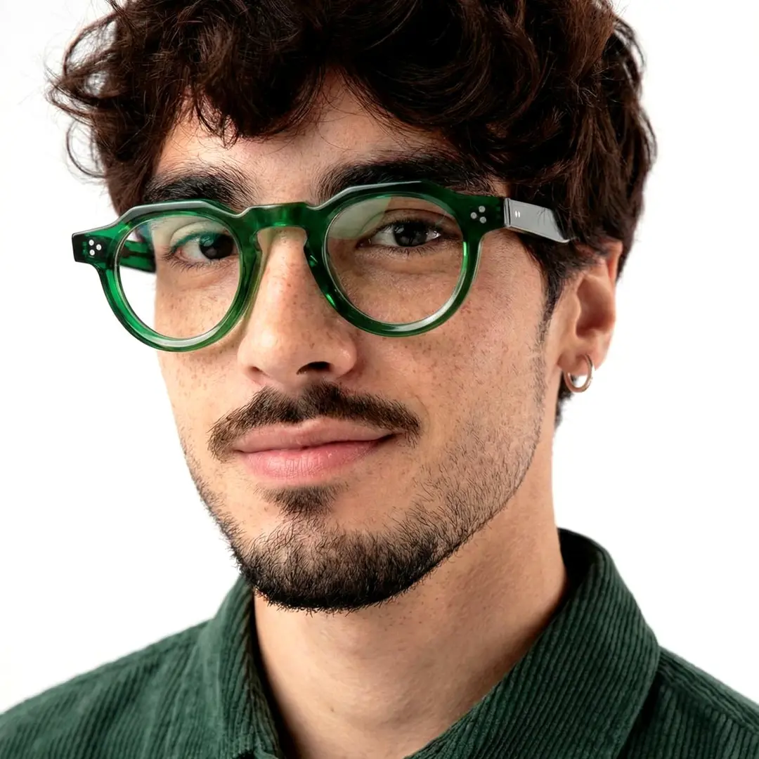 Slightly angled view of male wearing green round eyeglasses, natural expression, RA0012412
