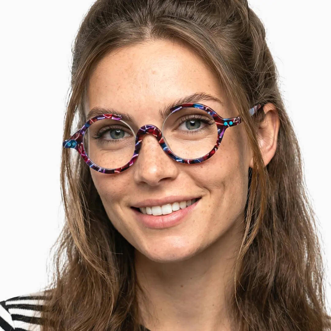 Front view of female wearing red tortoise round eyeglasses, smiling, RA0022212