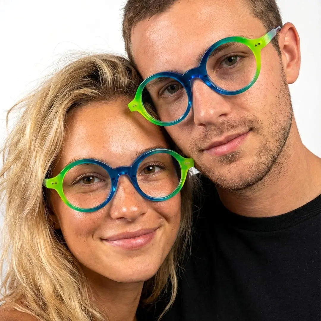 Front view of couple wearing blue round eyeglasses, smiling, RA0022307