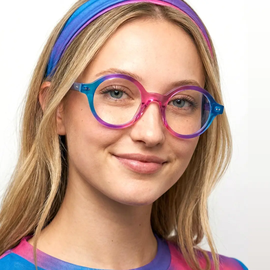 Face close-up view of female wearing colorful pink round eyeglasses, smiling, RA0022307