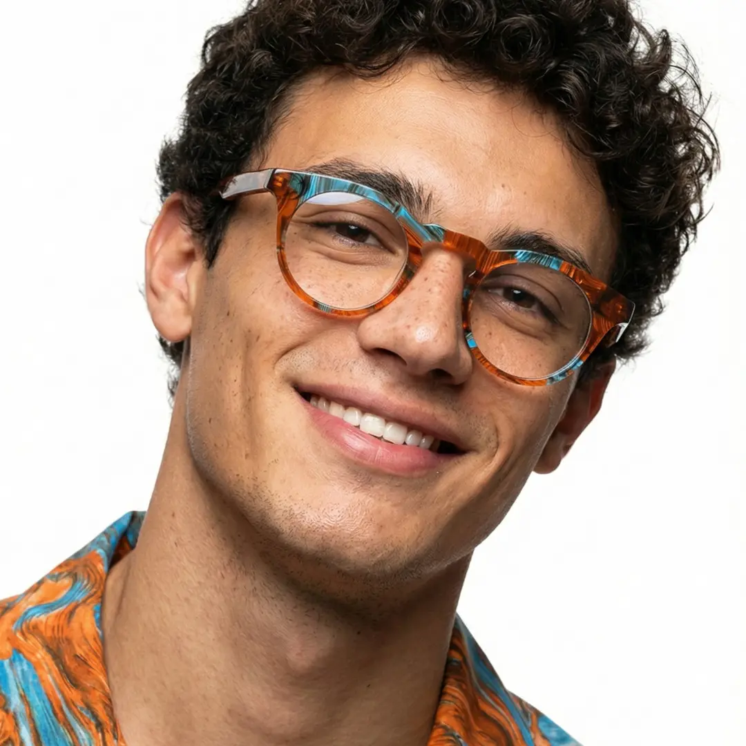 Three-quarter view of male wearing colorful orange round eyeglasses, tilting head, natural smile, RA0032303