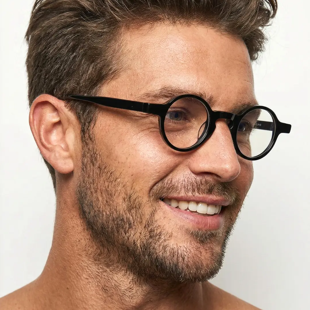 Profile view of male wearing vintage black round eyeglasses, smiling, RA0042303