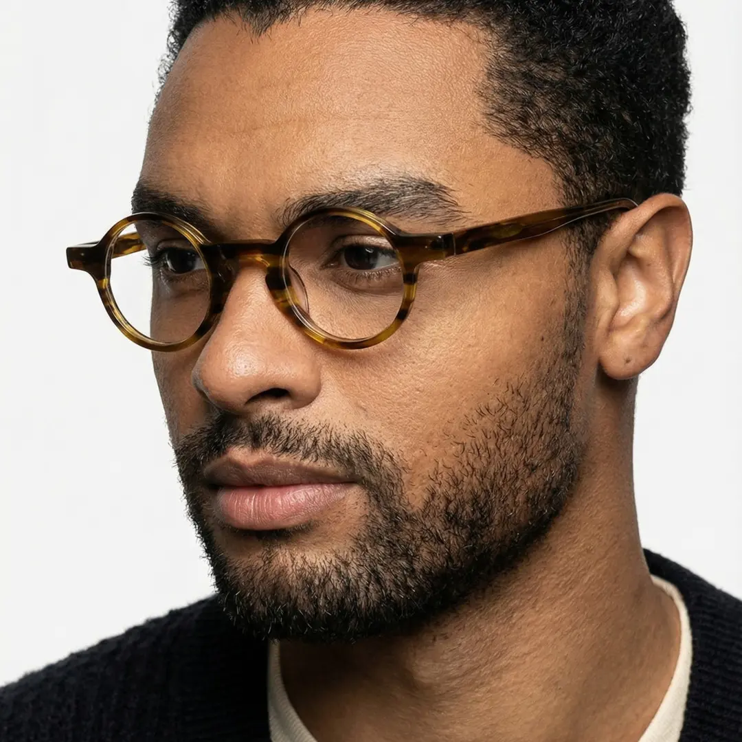 Three-quarter view of male wearing vintage yellow tortoise round eyeglasses, relaxed expression, RA0042303