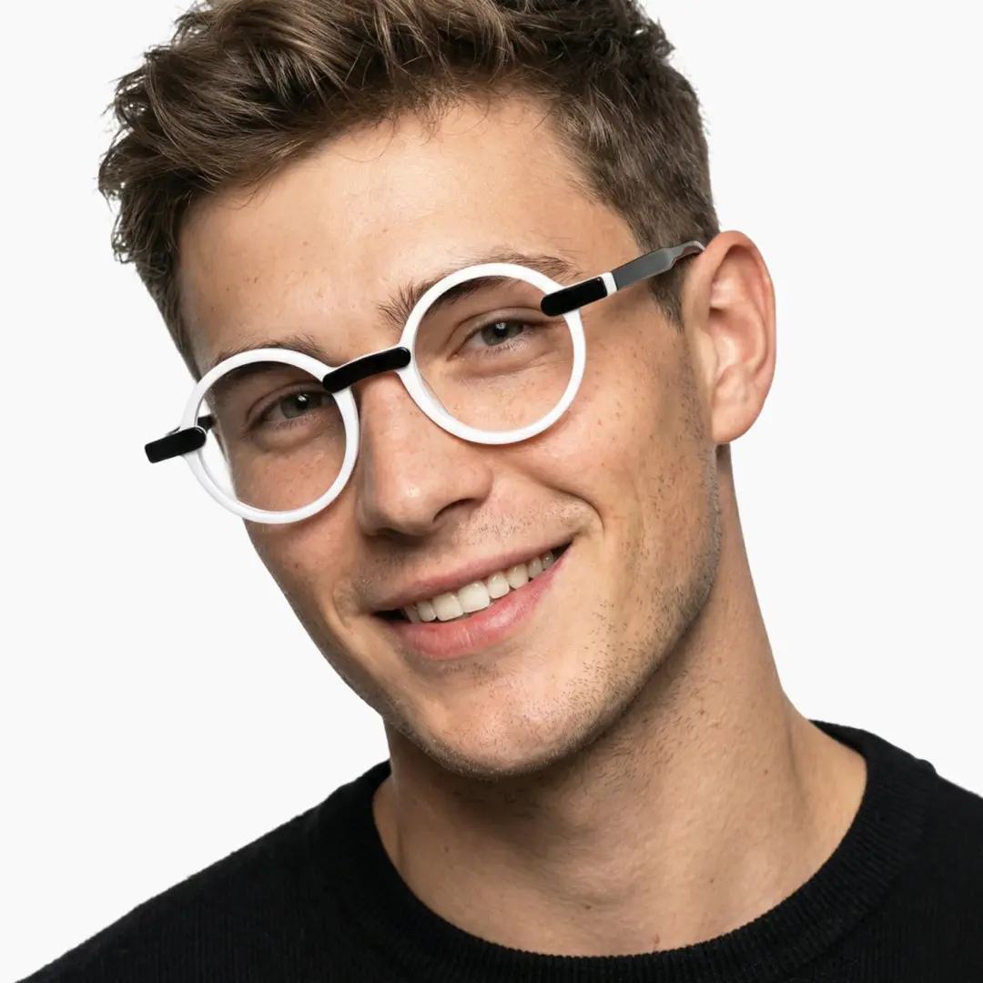Front view of male wearing black round eyeglasses, tilting head, natural smile, RA0052305
