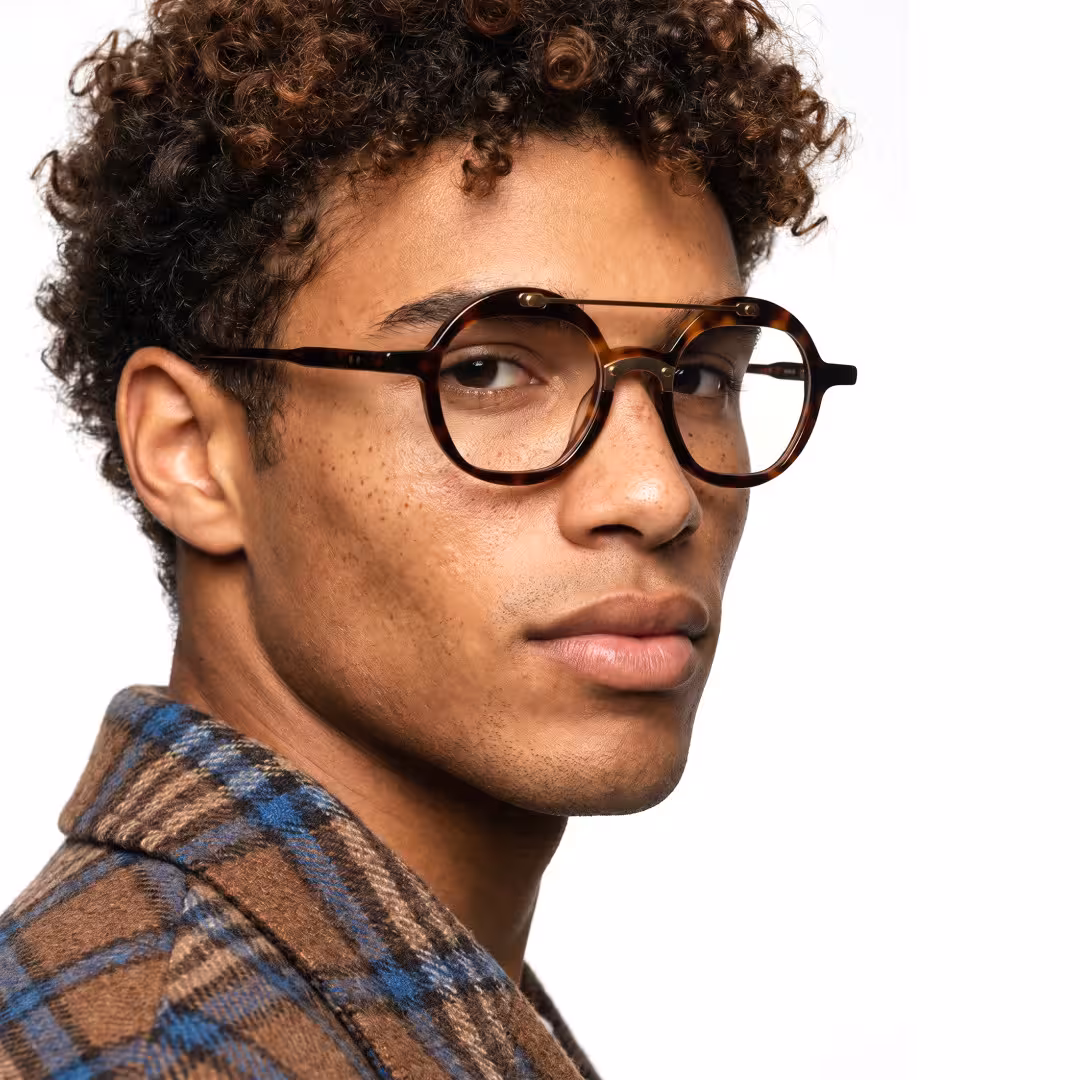 Male wearing vintage tortoise round acetate eyeglasses, maintaining a neutral expression while looking at camera. SPU: RA0052308