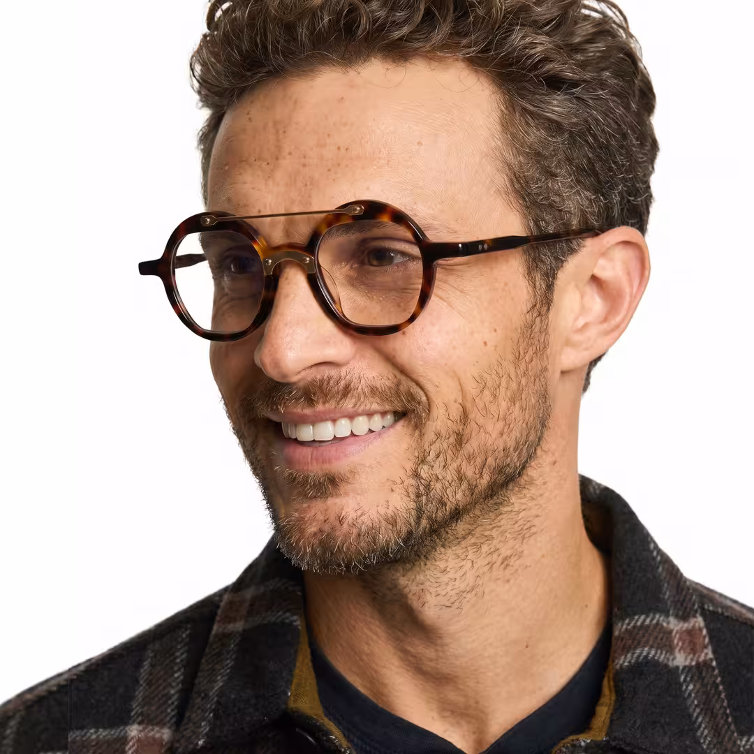 Male wearing vintage tortoise round acetate eyeglasses, smiling while looking away. SPU: RA0052308