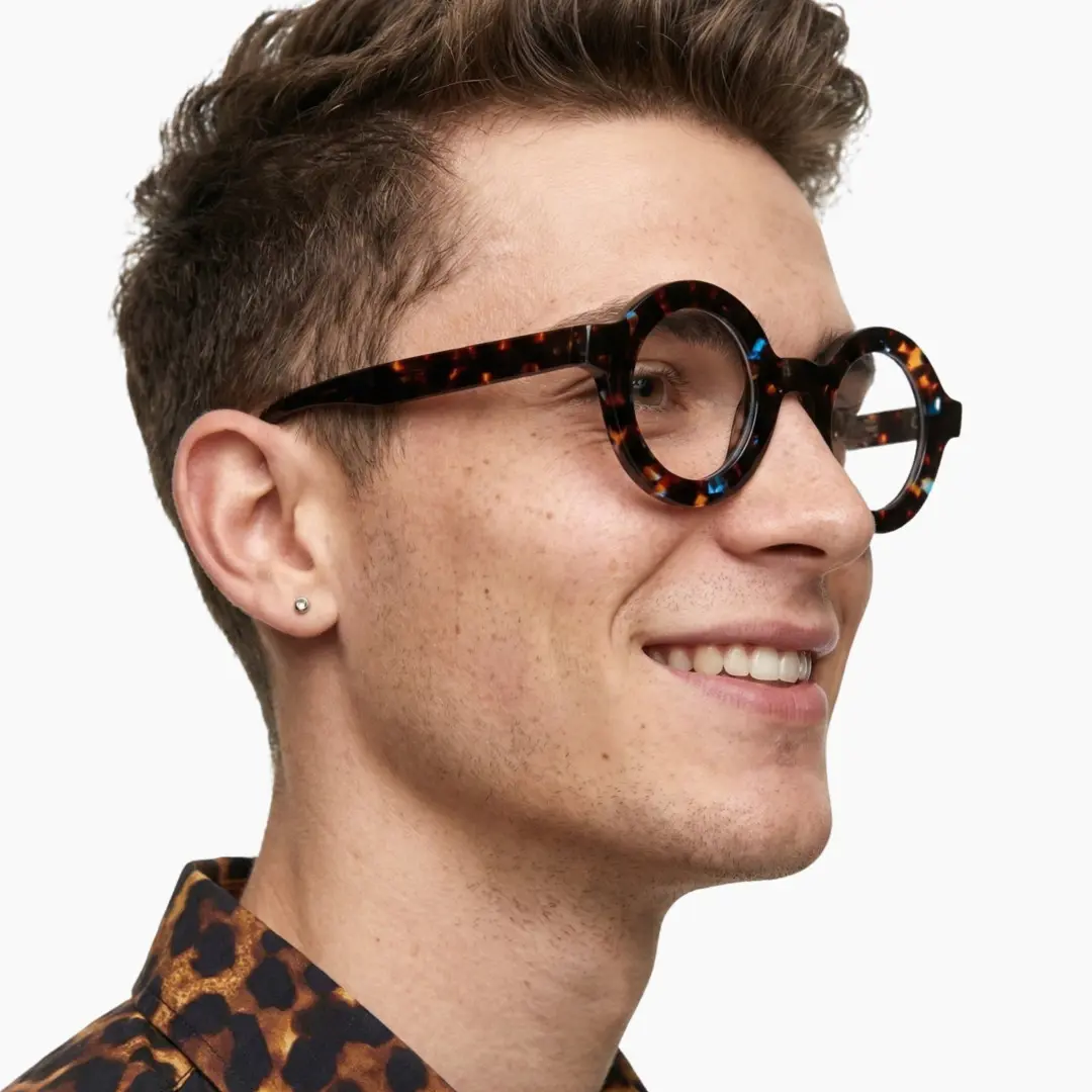 Profile view of male wearing brown tortoise round eyeglasses, friendly smile, RA0052408