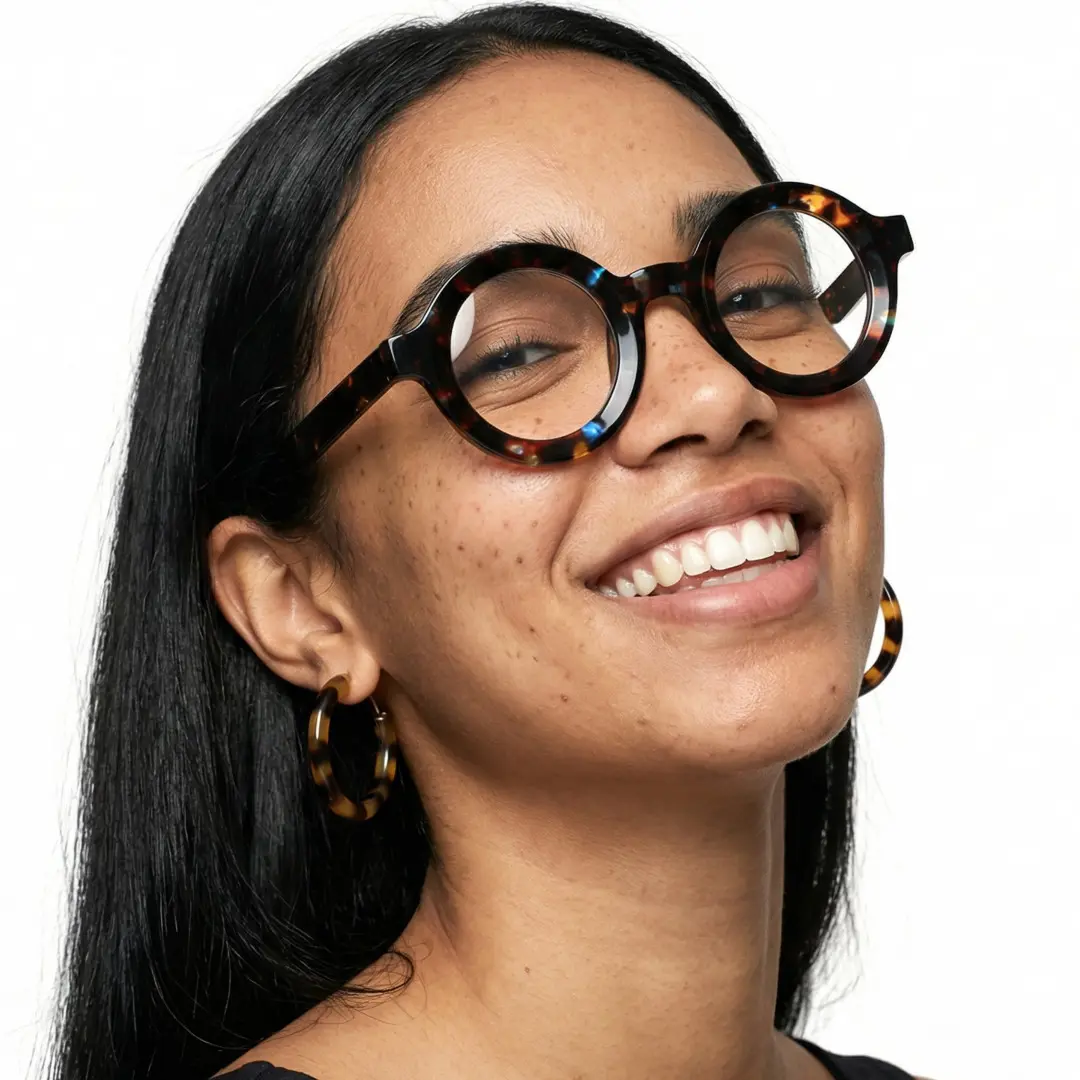 Face close-up view of female wearing brown tortoise round eyeglasses, big smile, RA0052408