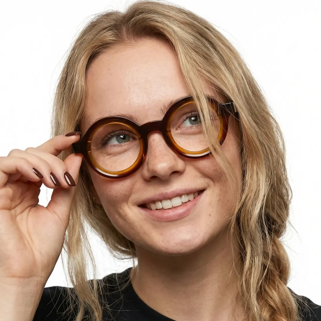 Front view of female wearing brown tortoise round eyeglasses, touching frame, natural smile, RA0052408